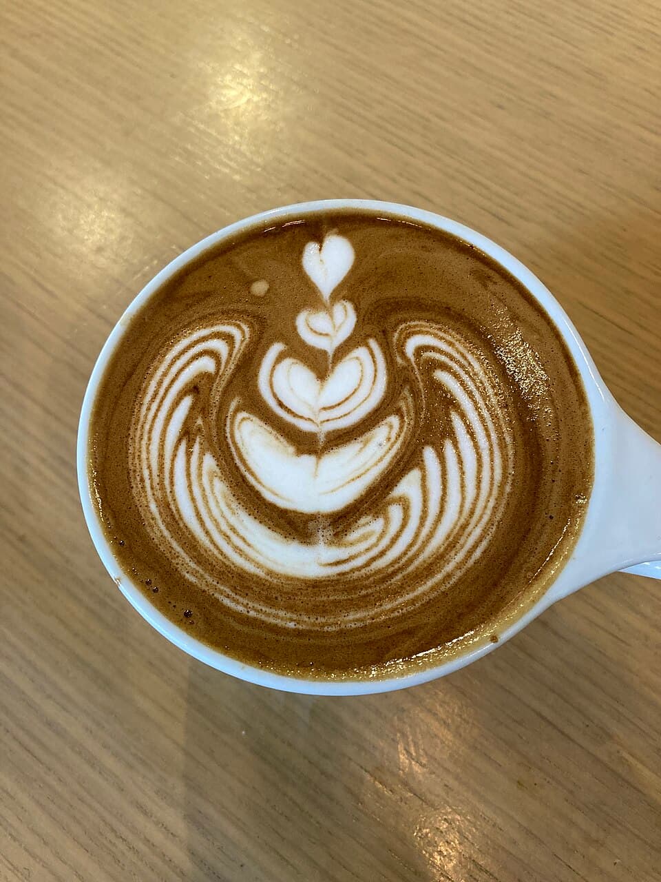 A flat white with a stacked tulip latte-art pattern in milk foam.